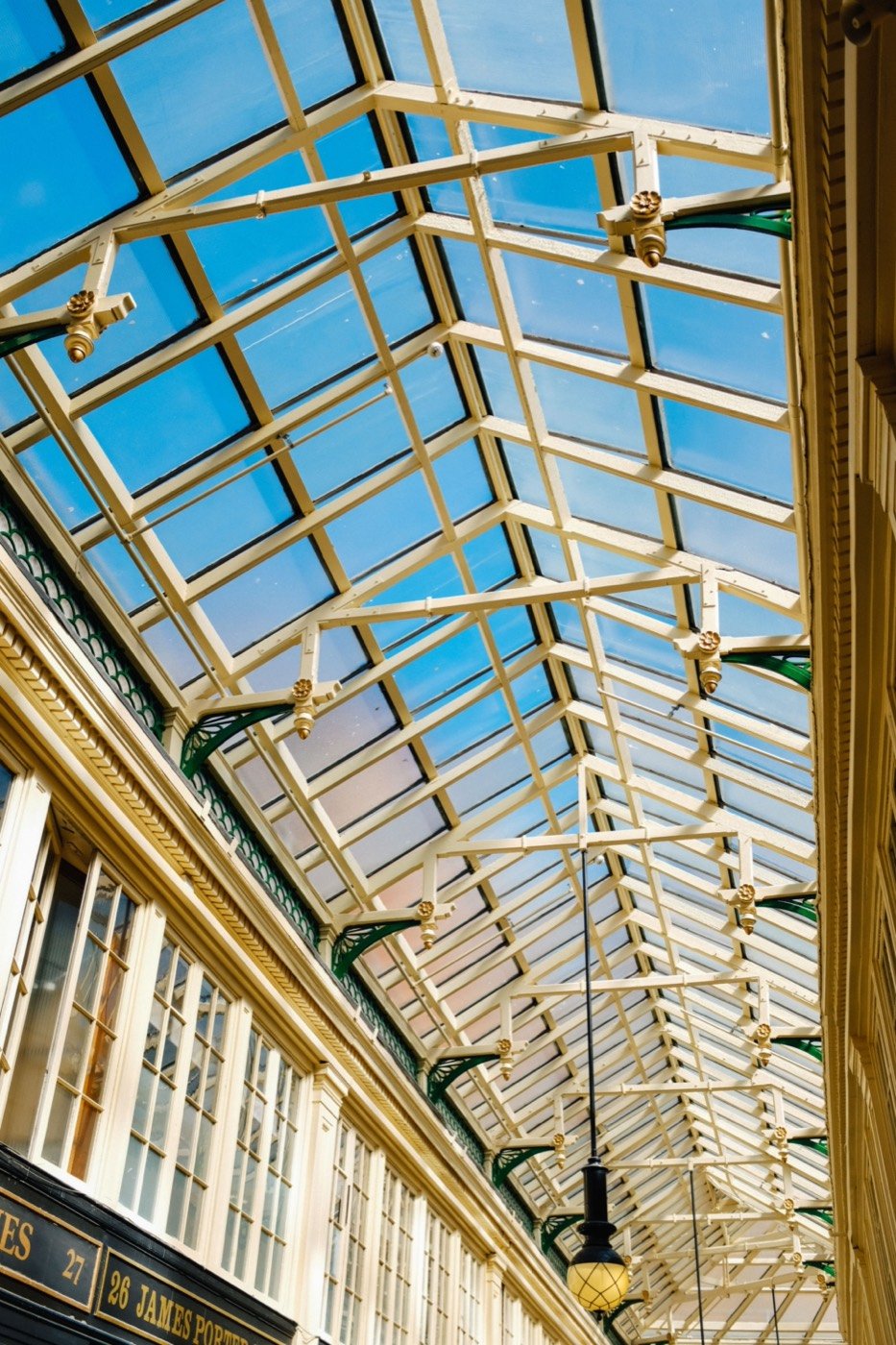 Restored Victorian arcade with an ornate glazed roof, showing preserved period architecture.